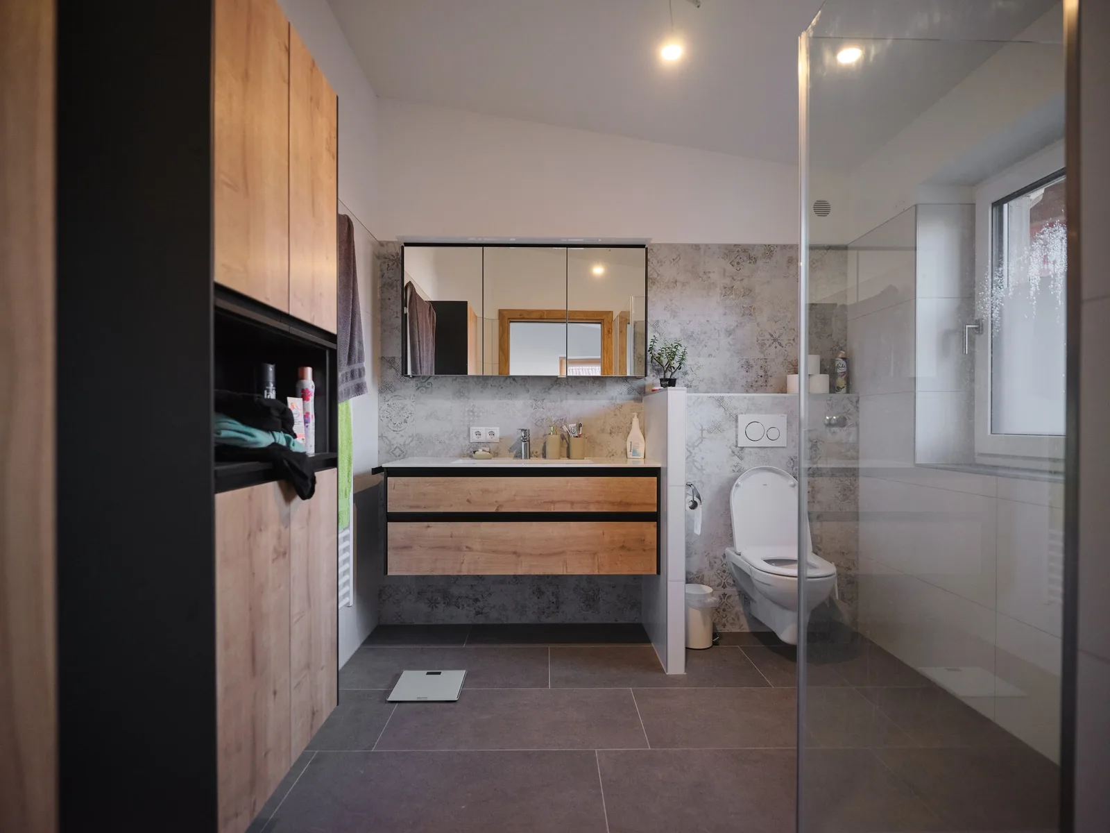 Gefliestes Bad mit Glasdusche und Waschtisch