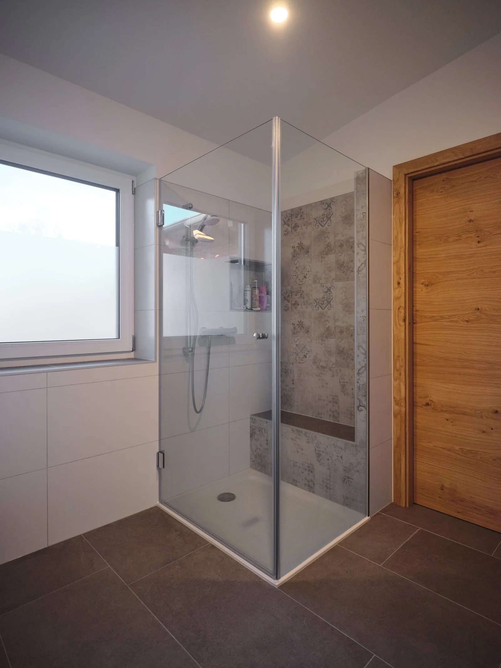Bodenebene geflieste Dusche mit Glaswand