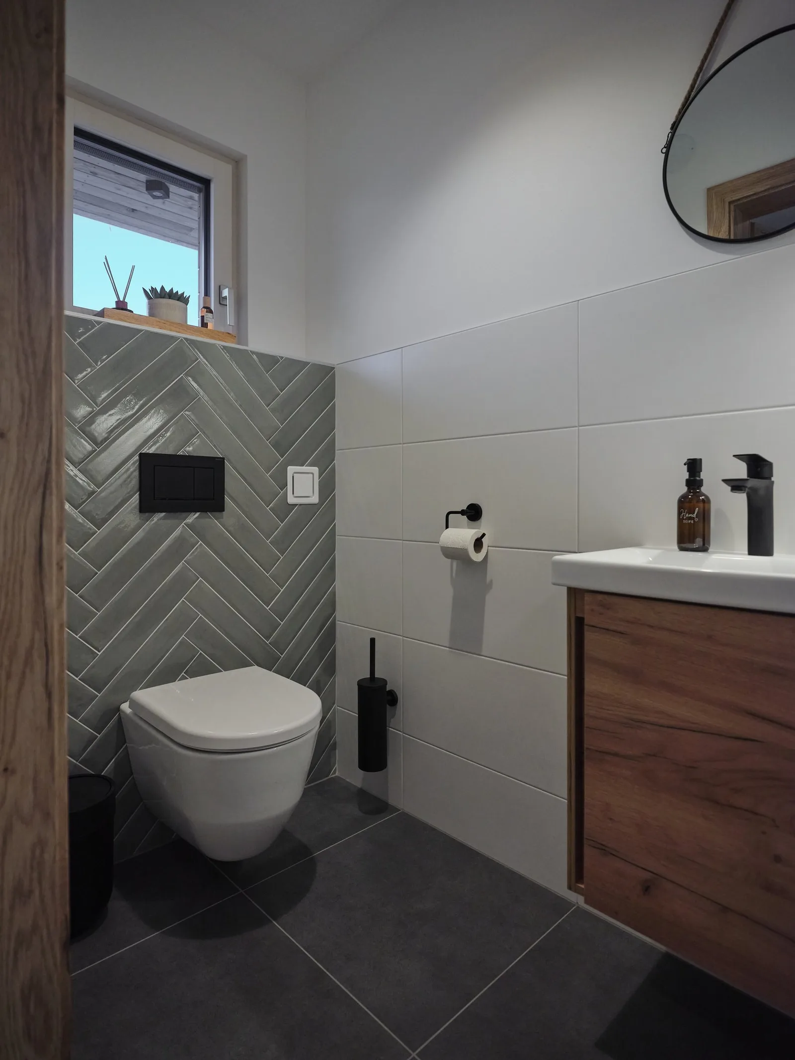 WC mit grünen Fliesen im Fischgrätmuster