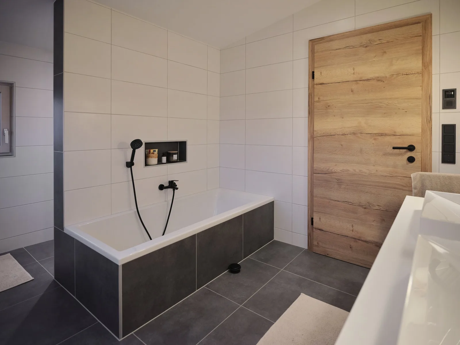 Geflieste Wanne neben einer Holztür