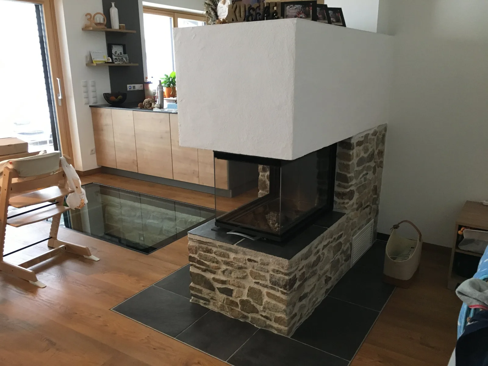 Weißer dreiseitiger Kamin mit dunklem Sockel